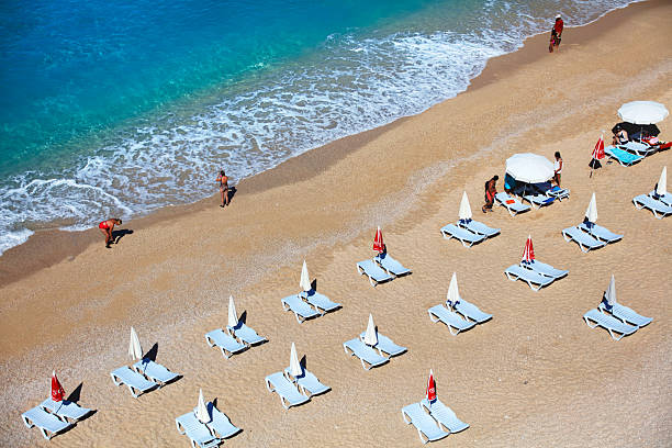 Antalya, Turkey - June 21, 2016: op view of famous canyon junction beach of Antalya, Kaputas Beach with its turquoise water color, view of people swimming and sunbathing at sunset background.