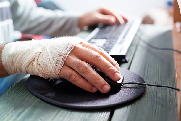 bandaged hand on mouse bandaged hand on mouse ergonomic keyboard photos stock pictures, royalty-free photos & images