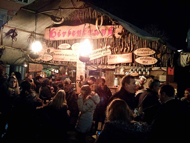 Esslingen am Neckar, Germany - November 30, 2015: Night shot of people enjoying food in front of a vendor stall at Christmas Market in Esslingen, mobile stock