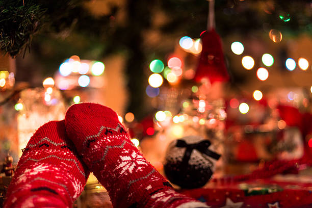 istock Feet wearing festive socks beneath illuminated Christmas tree 629569826