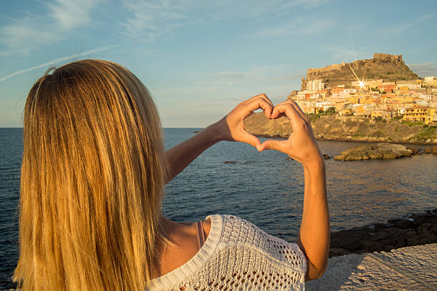 istock Young woman in Italy makes a heart shape finger frame 629570336