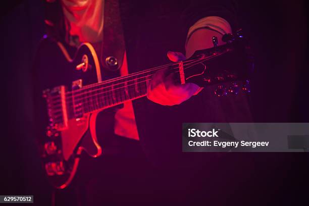 Guitar Player On A Stage With Red Light Stock Photo - Download Image Now - Guitar, Music, Playing