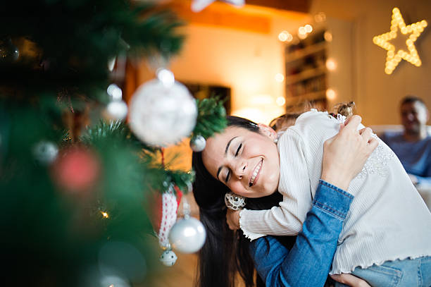 istock Young mother with daugter decorating Christmas tree together. 629582800