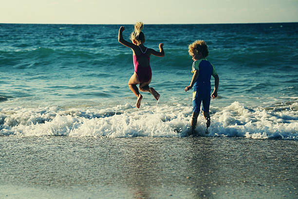 kids playing on the beach at sunset