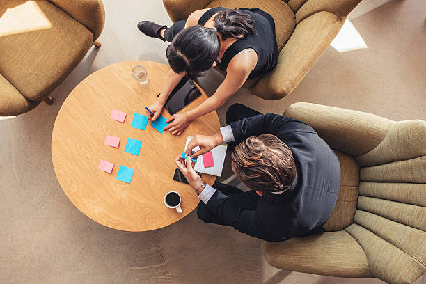 istock Businesspeople discussing over adhesive notes in office lobby 629586366
