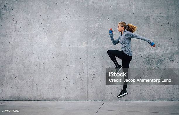 Mujer Joven En Forma Haciendo Entrenamiento De Intervalos Cardiovasculares Foto de stock y más banco de imágenes de Precalentamiento