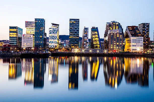 Oslo modern skyline. Several buildings built on the water's edge in the Norwegian capital city. Reflections on the water.