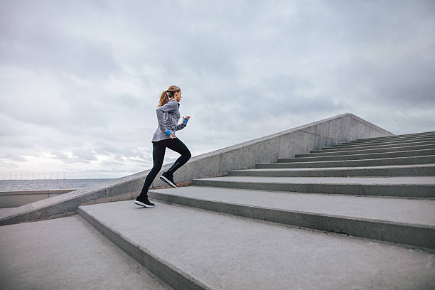 mujer sana subiendo escaleras - staircase running moving up jogging fotografías e imágenes de stock