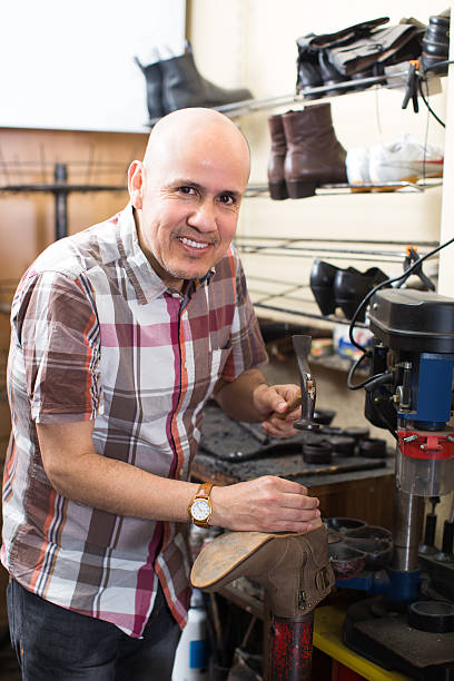 istock Workman repairing pair of shoes 629592106