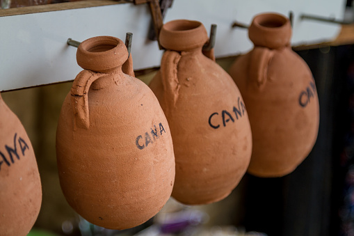 The pottery jugs, small souvenirs imitating ancient wine jugs in the gift shop in Cana of Galilee, Israel. Selective focus