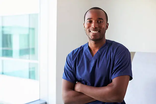 Photo of Portrait Of Male Nurse Wearing Scrubs In Exam Room