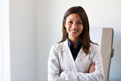 Retrato de una doctora con bata blanca en la sala de exámenes photo