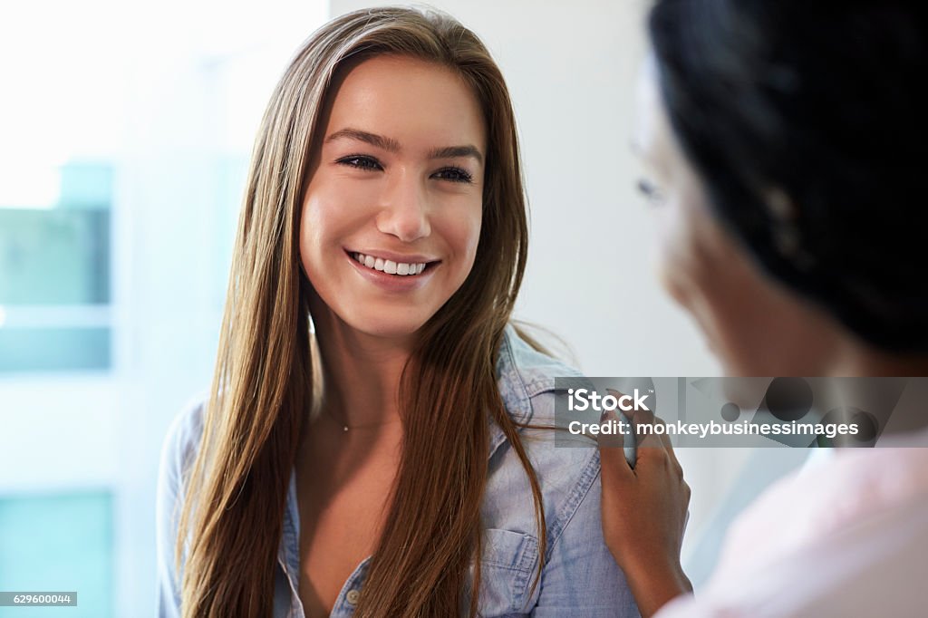 Female Doctor Meeting With Teenage Patient In Exam Room Hand On Shoulder Stock Photo