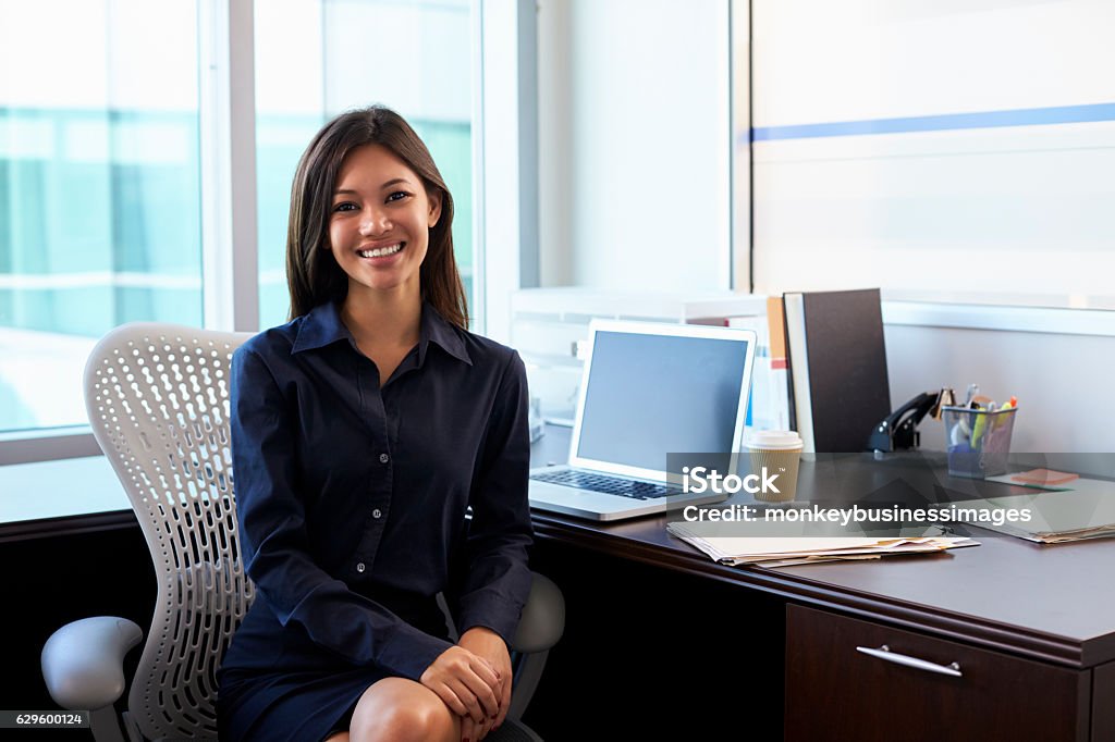 Portrait Of Female Doctor Sitting At Desk In Office Expertise Stock Photo