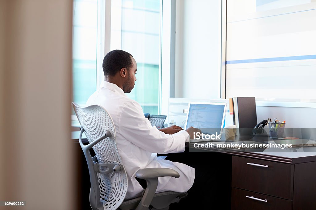 Doctor Wearing White Coat Working On Laptop In Office Doctor Stock Photo