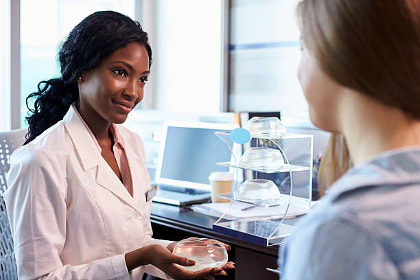 Breast Surgery Consultant Meeting With Female Patient Breast Surgery Consultant Meeting With Female Patient breast augmentation stock pictures, royalty-free photos & images