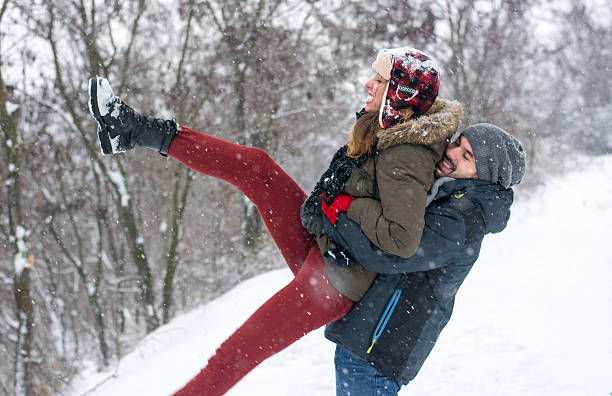 istock Couple having fun in snow covered park 629603176