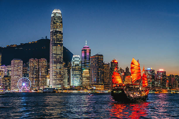 stadtbild hongkong und junkboat bei twilight - harbor city stock-fotos und bilder
