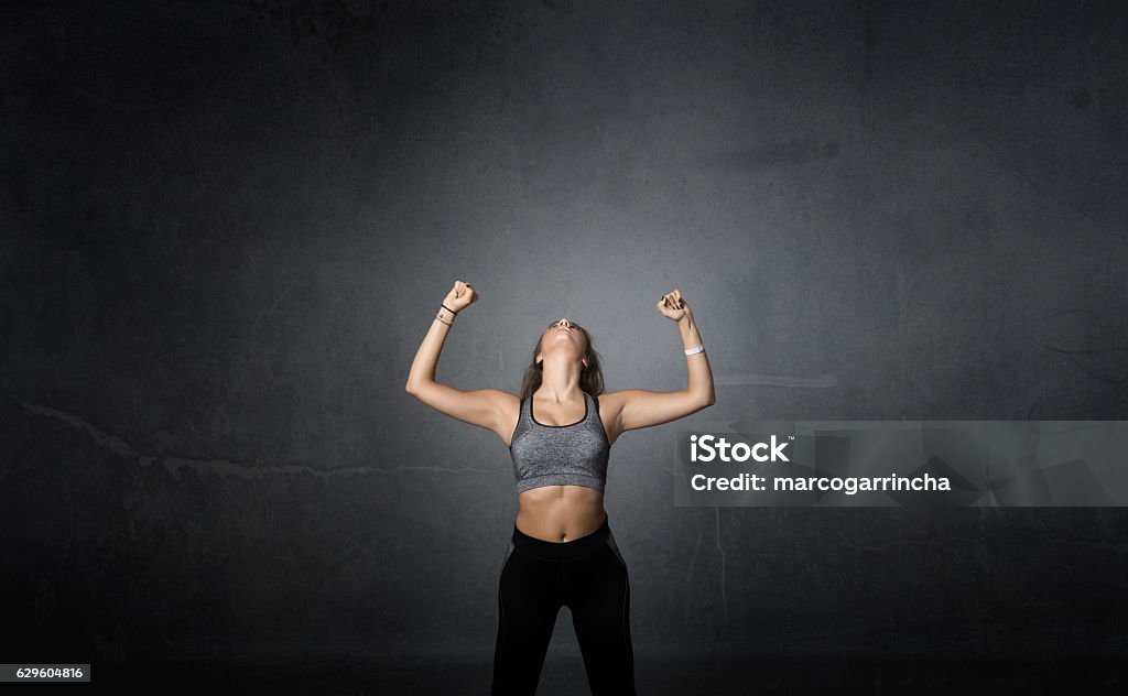 winner with arms up winner with arms up, dark background Health Club Stock Photo