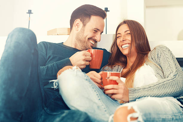 heureux jeune couple à la maison - comfortable relaxation sofa men photos et images de collection