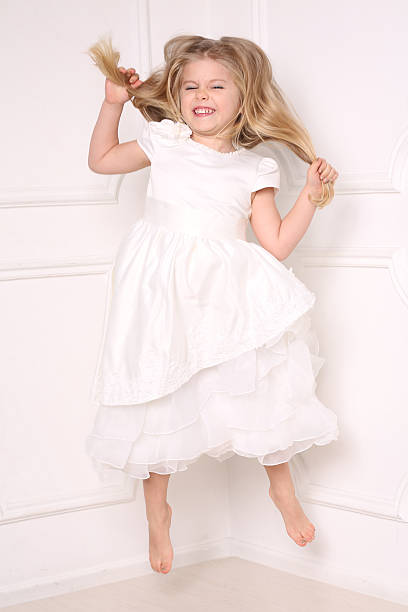 드레스 점프와 그녀의 머리를 들고 아이. 흰색 배경 - judy garland 뉴스 사진 이미지