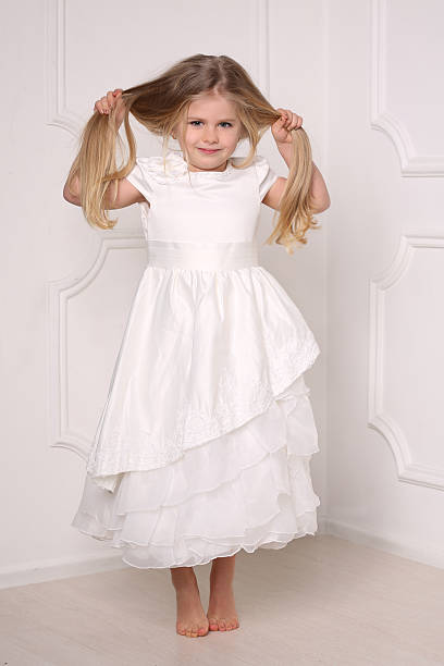 petite princesse en robe tenant ses cheveux. fond blanc - judy garland photos et images de collection