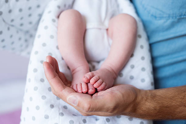 istock Unrecognizable father with newborn baby son, legs and hand 629612628