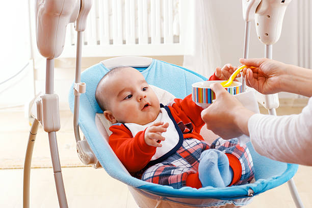 istock Baby boy eating with spoon at home 629613602