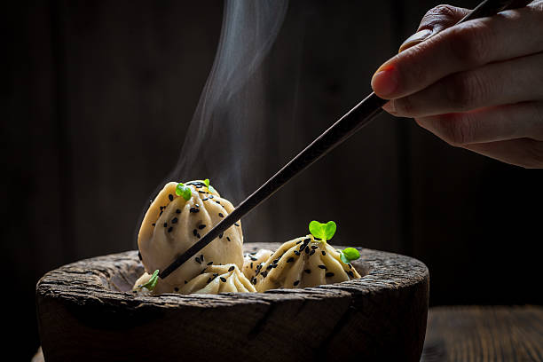 leckere und heiße chinesische knödel in holzschale - asiatische küche stock-fotos und bilder