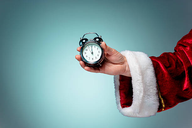 istock Santa holding an old alarm clock 629616998