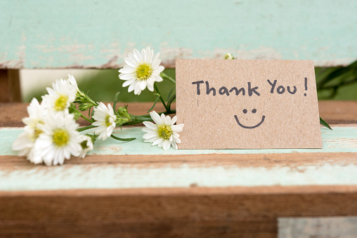 Nota de agradecimiento con cara de sonrisa y racimo de flores photo