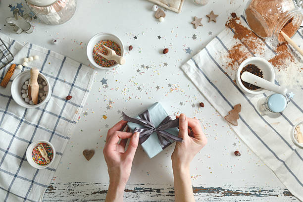 istock Woman bows tie on christmas present with a blue ribbon 629630068