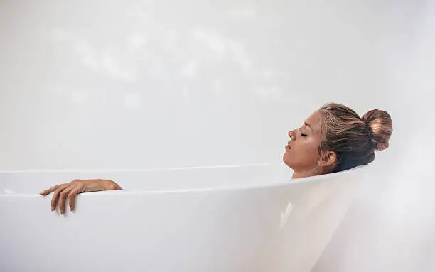 Photo of Young woman relaxing in bathtub