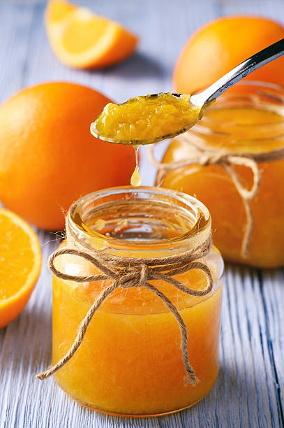 istock Orange jam in glass jar on wooden background. 629642700