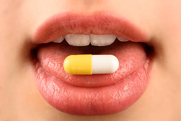 медицина  - vitamin pill picking up pill capsule стоковые фото и изображения