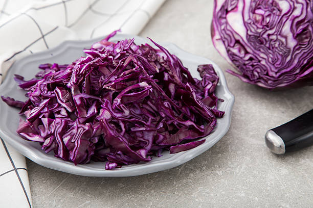 istock Shredded red cabbage in clay bowl on stone background. 629652976