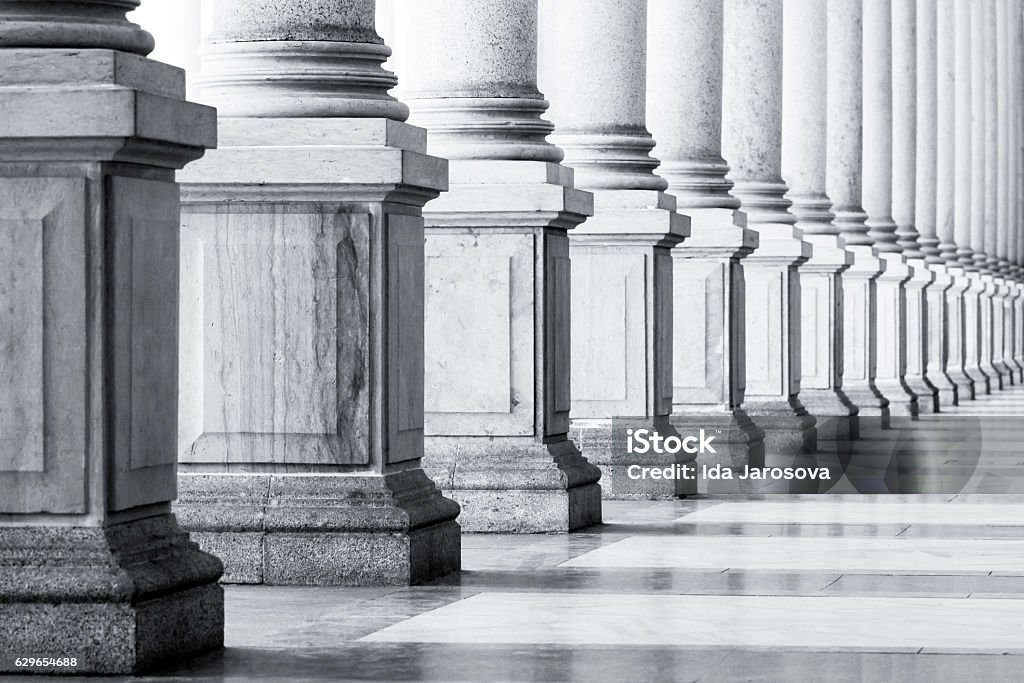 Black and white row of classical Columns with copy space, Closeup black and white row of classical marble columns. Symbols of integrity, stability, and trustworthiness.  Detail of Mlynska colonnade Karlovy Vary Czech republic establish 1881, this is the biggest colonnade in Karlovy Vary. Full frame horizontal composition with copy space Justice - Concept Stock Photo