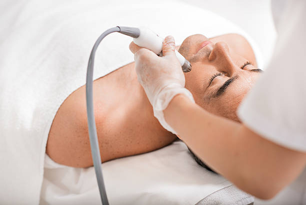 istock Skillful cosmetologist undergoing ultrasound anti-aging procedure 629654892