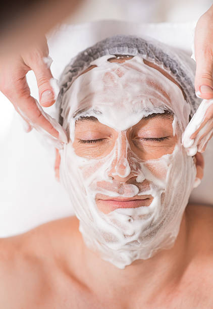 istock Cosmetologist doing facial massage with foam 629656180