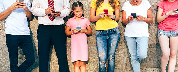 istock Little girl texting among adults 629656632