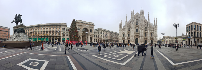Milano, Italy - December 14, 2016:  Piazza del Duomo during Christmas time. Many people walking on square. Many bilboards and banners on the square. The giant christmas tree is in the middle of the square.