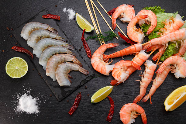 istock Raw and boiled shrimps on a stone plate 629664566