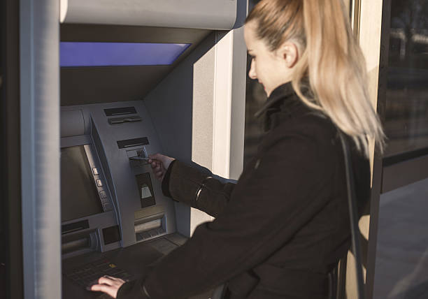 istock Woman inserting a credit card into ATM 629665822