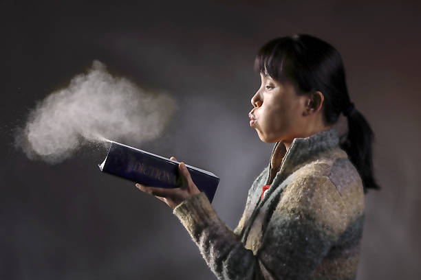 Cтоковое фото Сдувая пыль с книги.