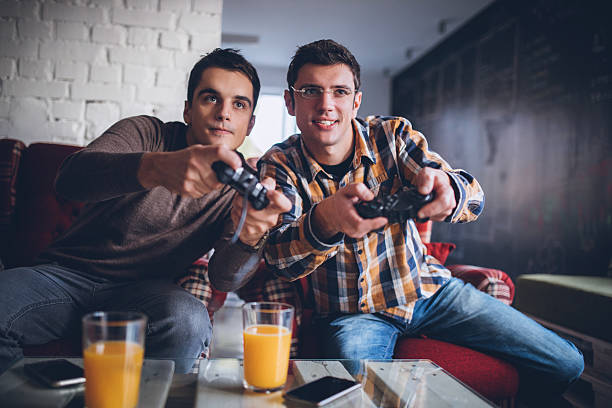 dwóch facetów grających w gry wideo w biurze - friendship video game young adult party zdjęcia i obrazy z banku zdjęć