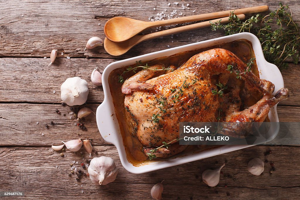 French Food: Chicken with 40 cloves of garlic French Food: Chicken with forty cloves of garlic in the dish for baking and ingredients close-up on the table. horizontal view from above Chicken Meat Stock Photo