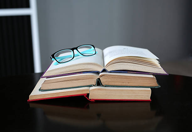 istock Open book and glasses on wood table. Education background. 629688294