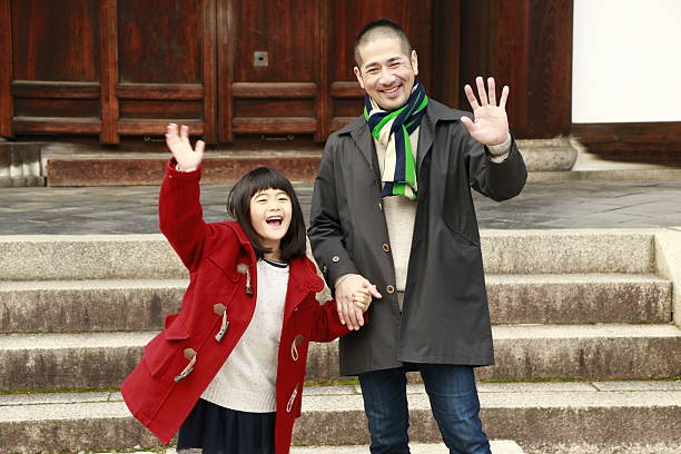 Father and daughter waving hand Father and daughter portrait rinzai zen buddhism stock pictures, royalty-free photos & images