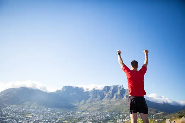 Photo of Successful sportsman stands on top of the mountain