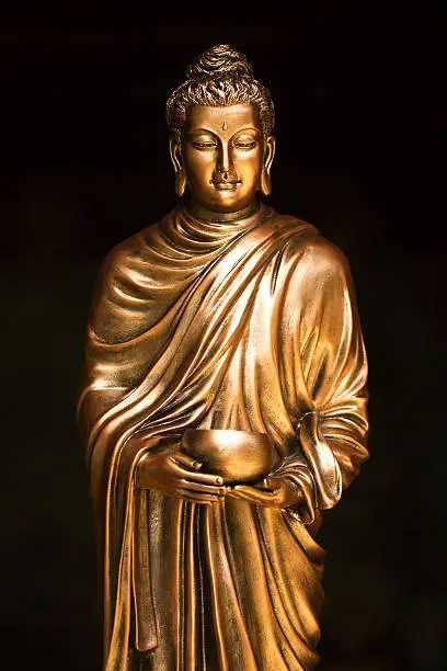 Photo of Buddha holding alms bowl statue in Theravada Buddhism